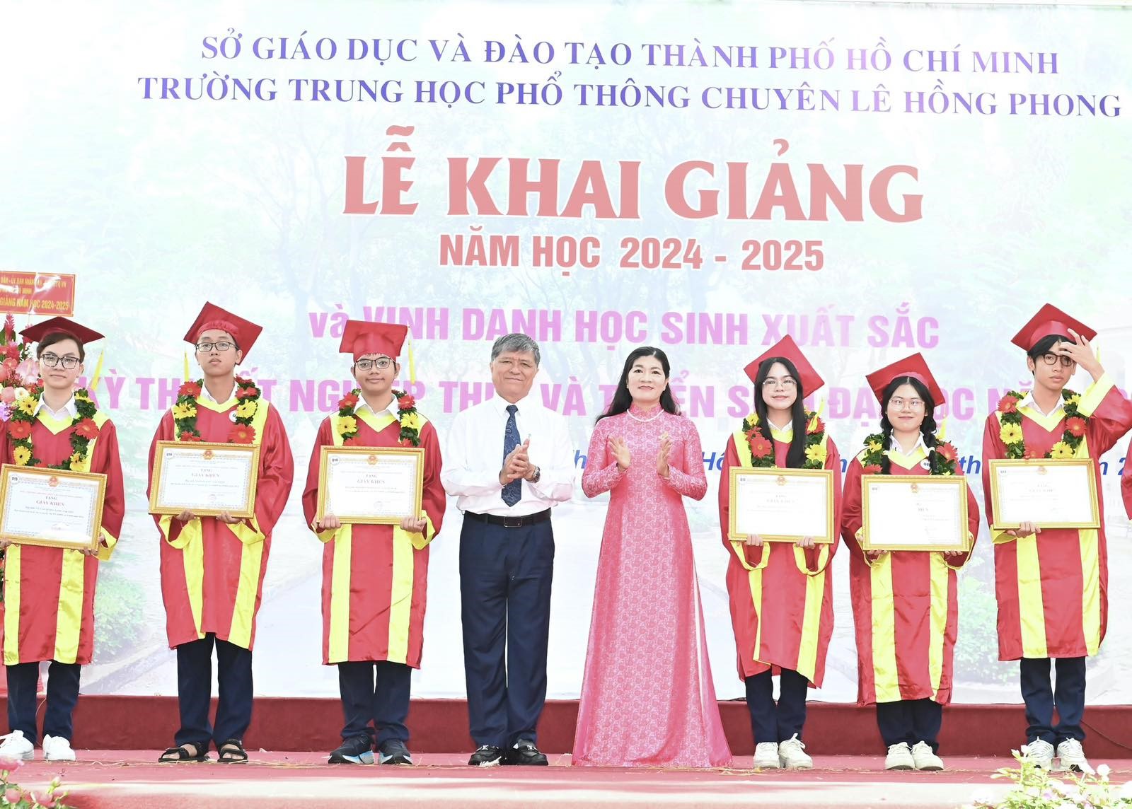 Giám đốc Sở GD-ĐT TP. Hồ Chí Minh Nguyễn Văn Hiếu và cô Phạm Thị Bé Hiền, Hiệu trưởng trường chuyên THPT chuyên Lê Hồng Phong, trao giấy khen và vòng hoa đến các em học sinh đạt thành tích cao trong các kỳ thi quốc gia và được tuyển thẳng vào trường đại học (Ảnh: Việt Dũng).